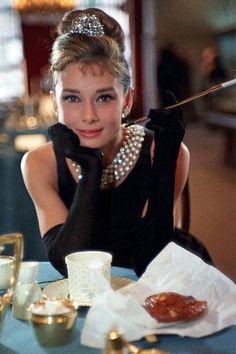 a woman sitting at a table with a cup and saucer