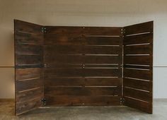 a room divider made out of wooden planks in an empty space with concrete flooring