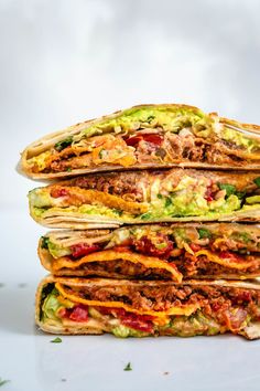 a stack of tortilla stacked on top of each other with meat and veggies