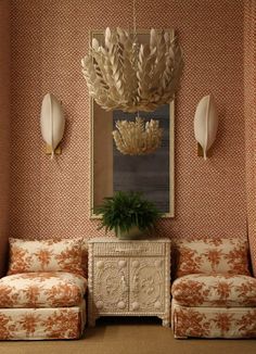 a living room with two couches and a table in front of the wallpaper