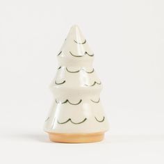 a small white ceramic christmas tree sitting on top of a table