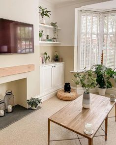 a living room filled with furniture and a flat screen tv mounted on the wall above a fireplace