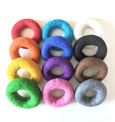 six different colored felt donuts sitting on top of each other