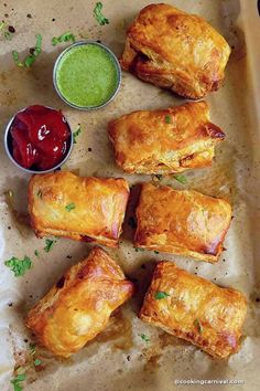 several pastries on a tray with dipping sauces and condiments next to them