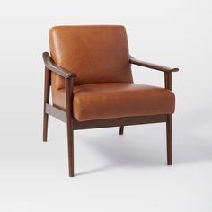 a brown leather chair sitting on top of a white floor next to a wooden frame