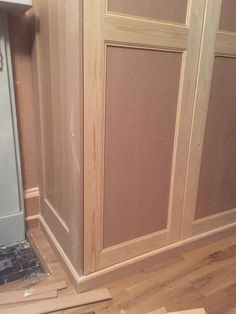 an unfinished kitchen with wood flooring and cabinets in the process of being installed on the wall