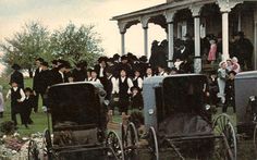 an old time photo of people and carriages in front of a house