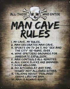 a sign that says man cave rules on the side of a building with skull and crossbones