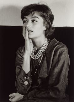 black and white photograph of a woman with her hand on her face while sitting down