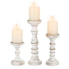 three white candles sitting next to each other