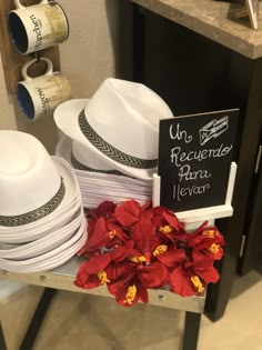 white hats and red flowers sit on a table with a sign that says, una recuerios para verar