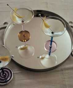 three martini glasses with lemon wedges on a silver tray