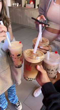 three people holding up drinks in front of each other at a coffee shop or cafe