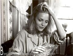 a black and white photo of a woman holding her hair in front of her face