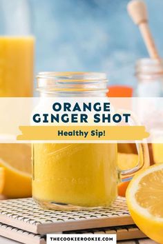 orange ginger shot in a mason jar next to sliced lemons