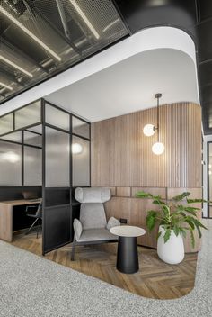 an office with wooden paneling and white walls, two chairs and a plant in the corner