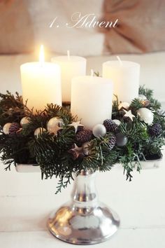 an image of a candle holder with candles on it and greenery in the center