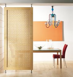 a dining room with a table and chairs next to a wall divider that has holes in it