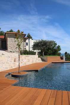 a wooden deck next to a swimming pool