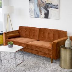 a living room filled with furniture and a painting on the wall