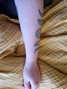 a person's foot with tattoos on it sitting on top of a yellow blanket