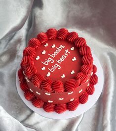 a heart shaped red cake with white hearts on it and the words happy birthday written on top