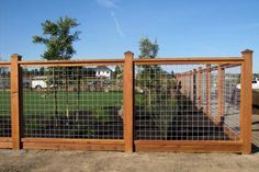 the fence is made of wood and has metal bars on each side, along with grass