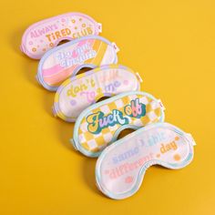 five different colored masks with words on them sitting on a yellow surface, one for each child's face and the other for children's mouth