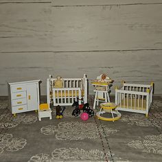 there are many toy cribs and toys on the floor next to each other