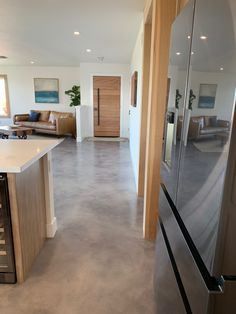 a modern kitchen with stainless steel appliances and white counter tops, along with an open floor plan