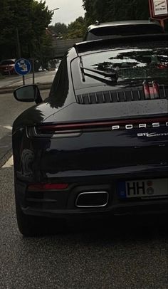 a black porsche parked on the side of the road