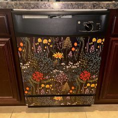 a black dishwasher sitting on top of a kitchen counter next to wooden cabinets