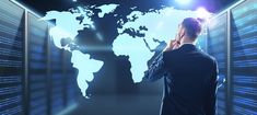 a man standing in front of a world map on a wall with data servers all around him