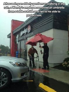 two men with umbrellas are standing in the rain outside a store on a rainy day