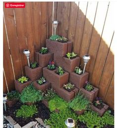 there is a very tall tower made out of cinder blocks with plants growing in it