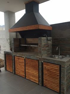 an outdoor kitchen with a grill and sink