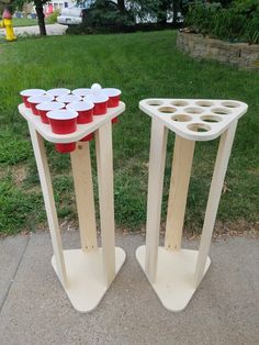 two wooden stands with cups on them in the grass