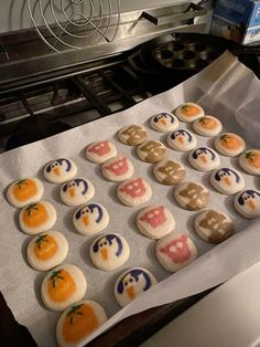 there are many decorated cookies on the baking sheet in front of the stove top oven