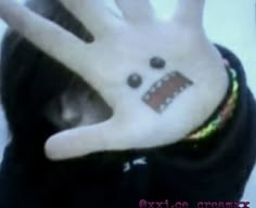 a person's hand with an evil face painted on it