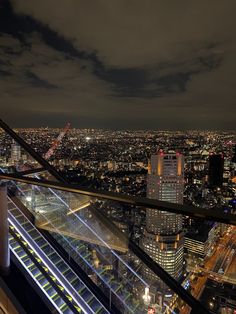 the city lights shine brightly at night in this view from top of a tall building