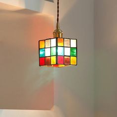 a multicolored light fixture hanging from a ceiling in a room with white walls