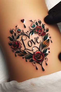 a woman's stomach with roses and the word love written in black ink on it