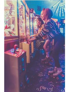 two people are playing video games in a room full of arcade machines and other items