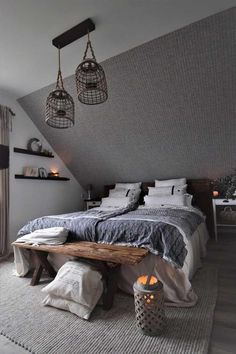 an attic bedroom with grey walls and white bedding, two hanging lights above the bed