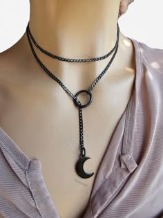 This is a bold and edgy blackened steel Gothic moon Lariat Necklace choker with a great Pagan witch aesthetic. The minimalist design gives it a trendy and stylish feel, while the black steel gives it a touch of gothic Punk edge. Please understand that this necklace is not designed for play, it is ornamental. This necklace is versatile and can be worn long or doubled up for a layered look, depending on what size you choose. Wrap it twice through the O ring to secure it in place. Gunmetal Minimalist Adjustable Jewelry, Trendy Black Lariat Jewelry, Gunmetal Adjustable Minimalist Jewelry, Handmade Black Lariat Necklace As Gift, Minimalist Gunmetal Metal Jewelry, Handmade Black Lariat Necklace For Gift, Edgy Gunmetal Jewelry With Adjustable Fit, Modern Black Lariat Jewelry, Handmade Black Lariat Necklace Gift