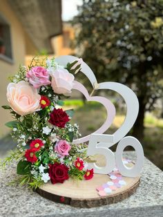 a wooden sign with flowers and hearts on it