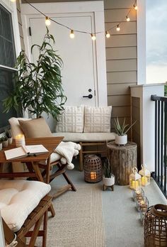 a porch with lights strung from the ceiling and wooden furniture on the front porch, along with potted plants