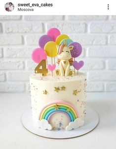 a birthday cake decorated with balloons and a unicorn