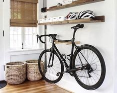 a bicycle mounted to the side of a wall in a room with wooden flooring