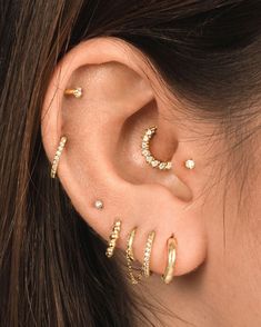 an ear with three different types of piercings on it, including the moon and stars